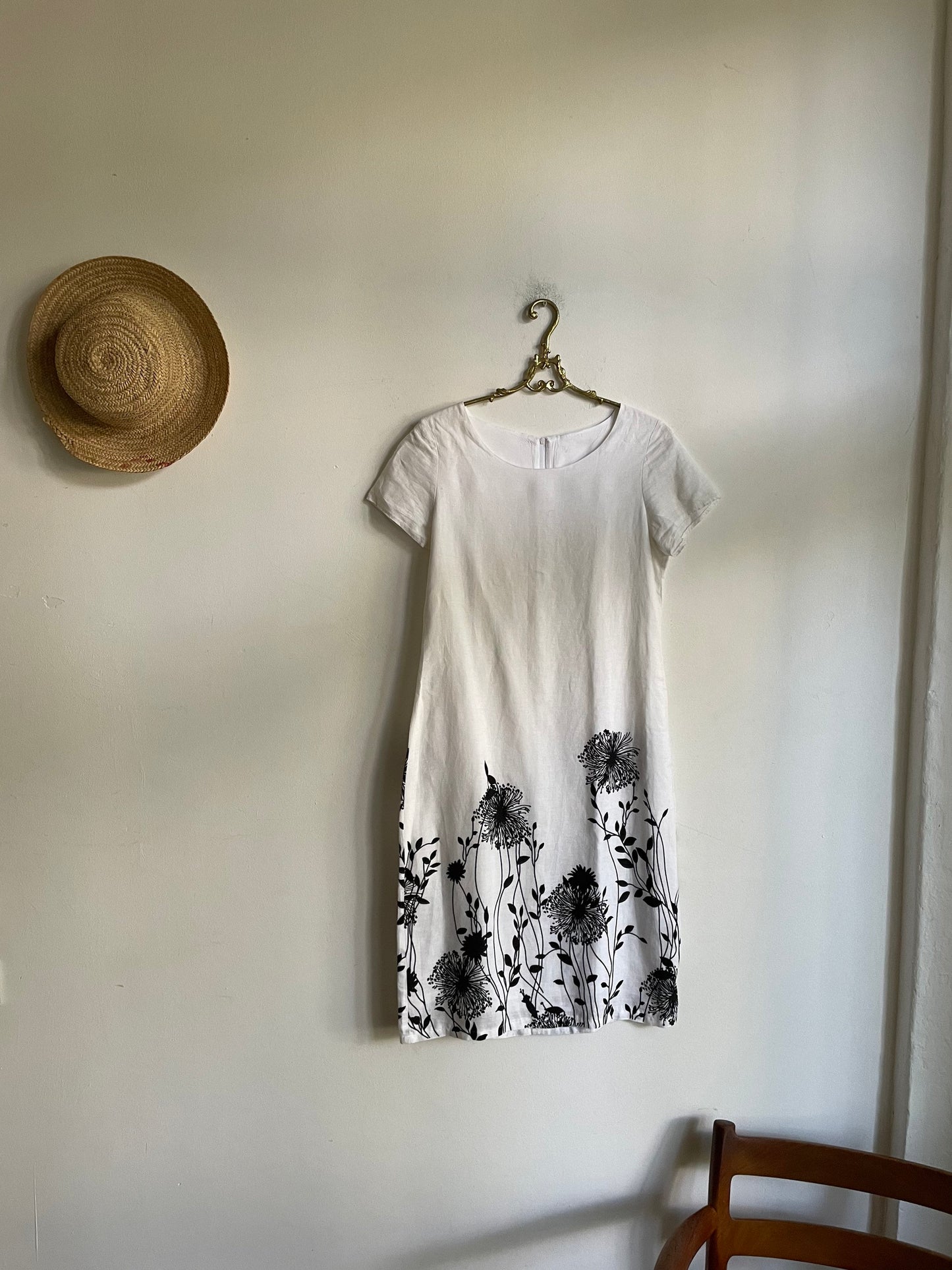 White linen summer dress with a black floral pattern,