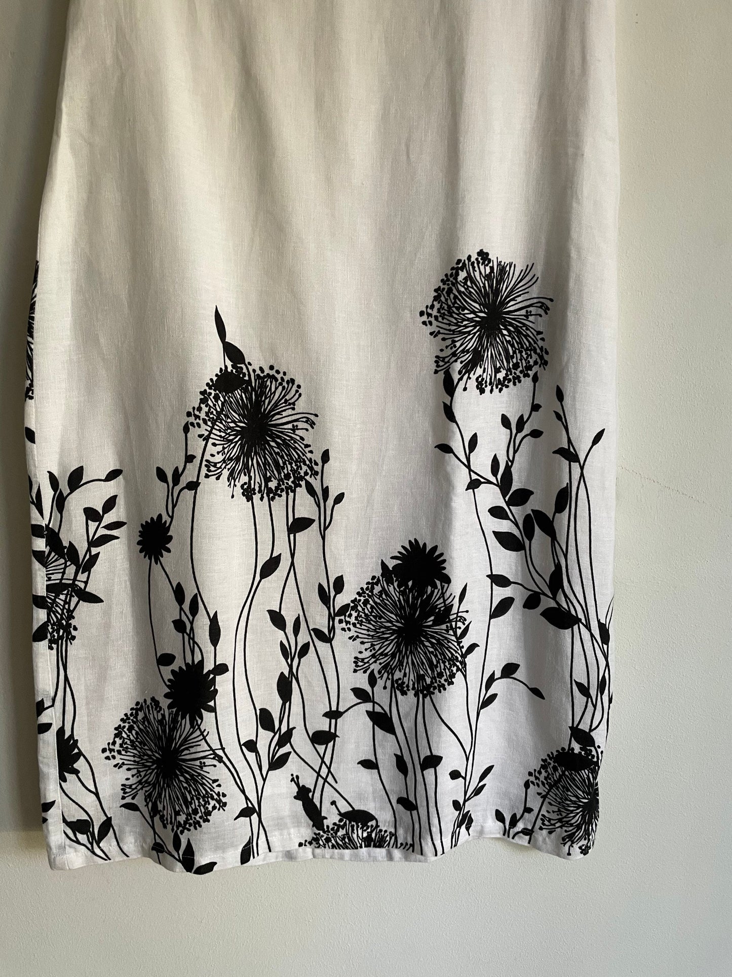 White linen summer dress with a black floral pattern,