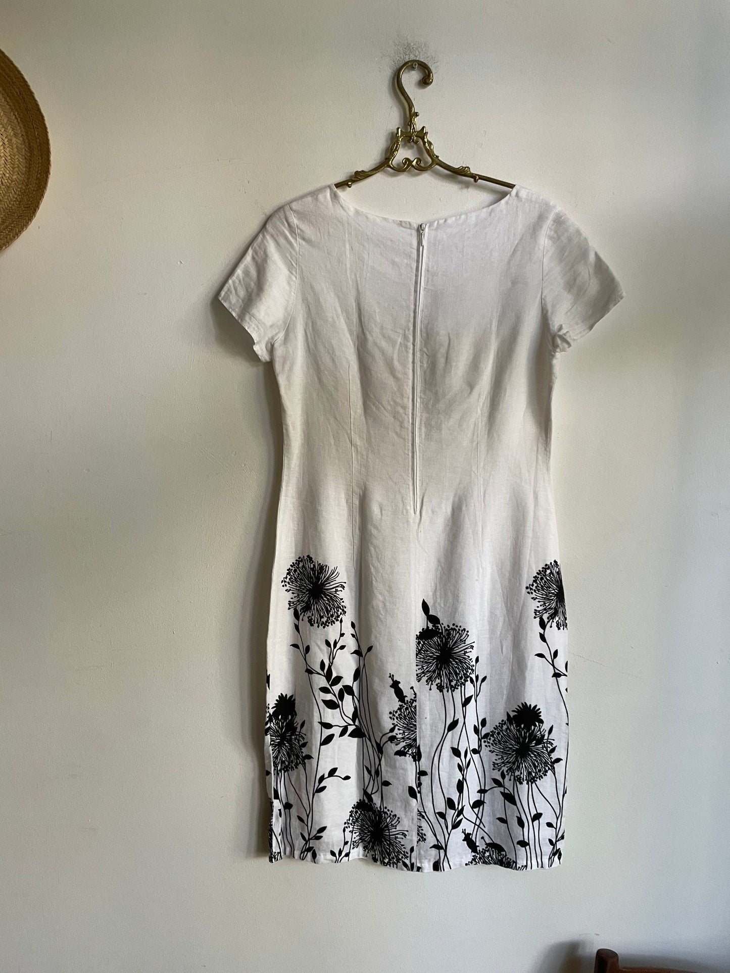 White linen summer dress with a black floral pattern,