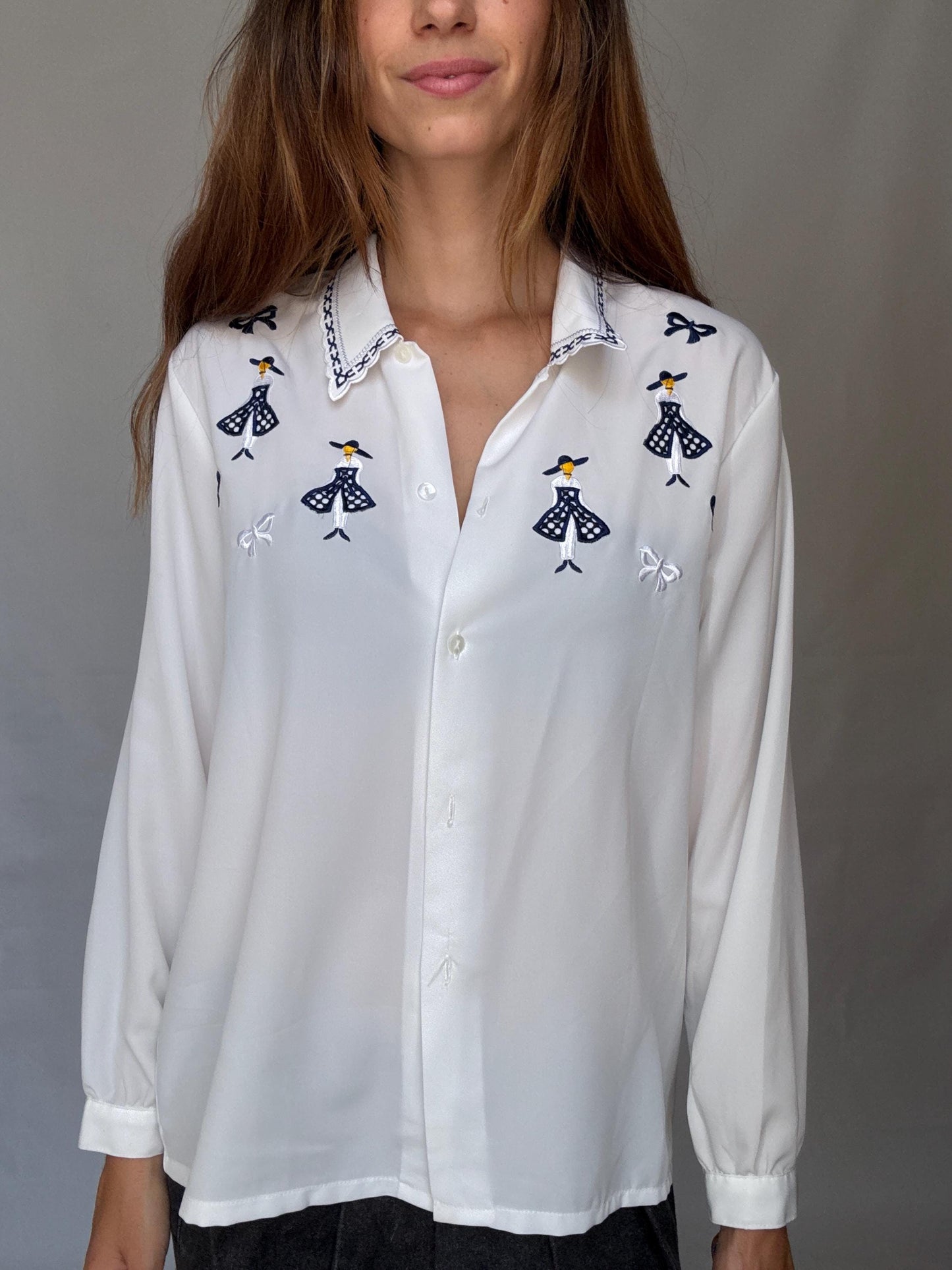 Vintage white embroidered blouse with navy bow and girl motif, shiny lightweight feel – schoolcore cottagecore US L