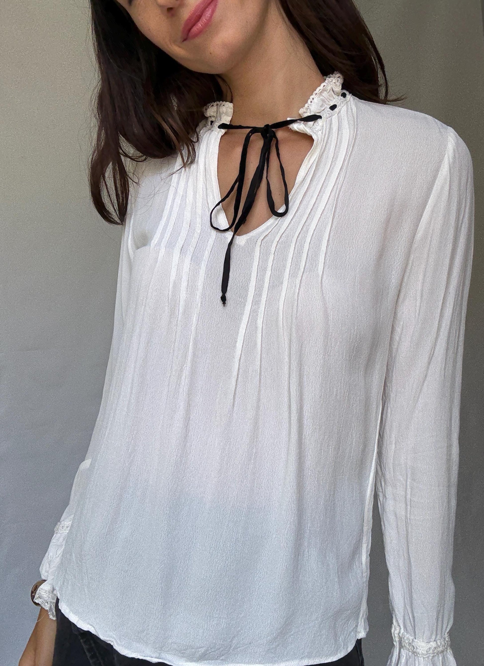 Romantic Bohemian White Blouse with Black Tie Detailing, Flowing Sleeves, and Ruffled V-Neck Inspired by Alexa Chung Style