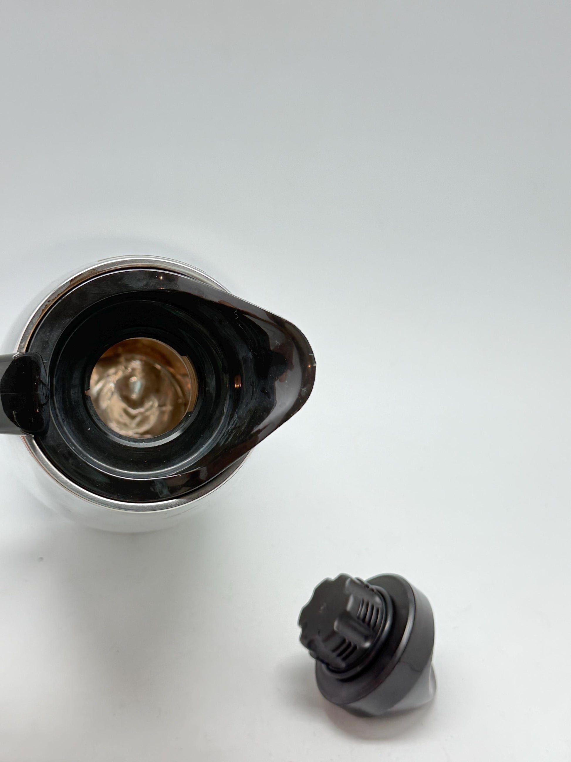 Modern stainless steel thermal carafe, double, wall insulation, sleek reflective finish, ergonomic handle, minimalist chic vibe