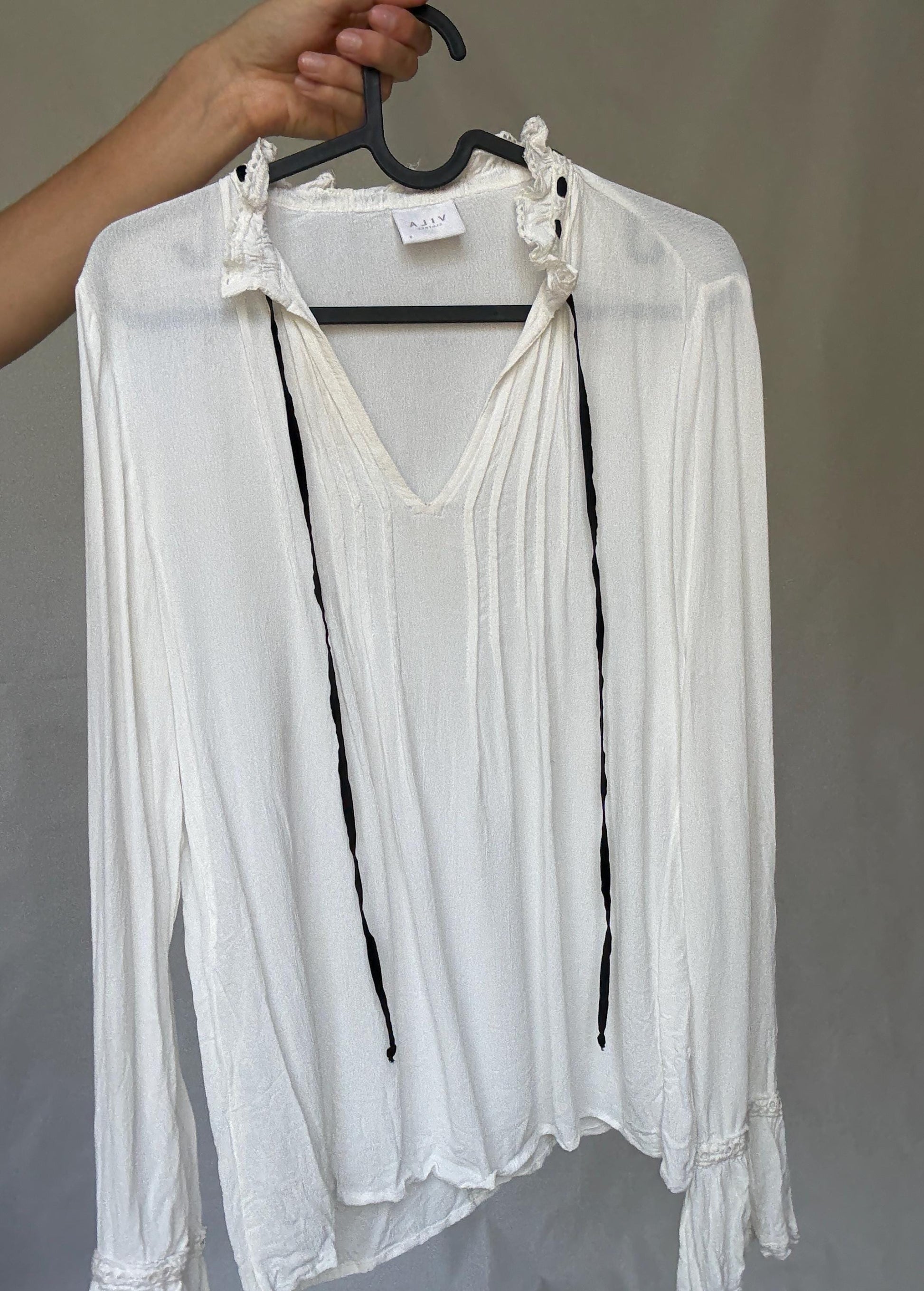 Romantic Bohemian White Blouse with Black Tie Detailing, Flowing Sleeves, and Ruffled V-Neck Inspired by Alexa Chung Style