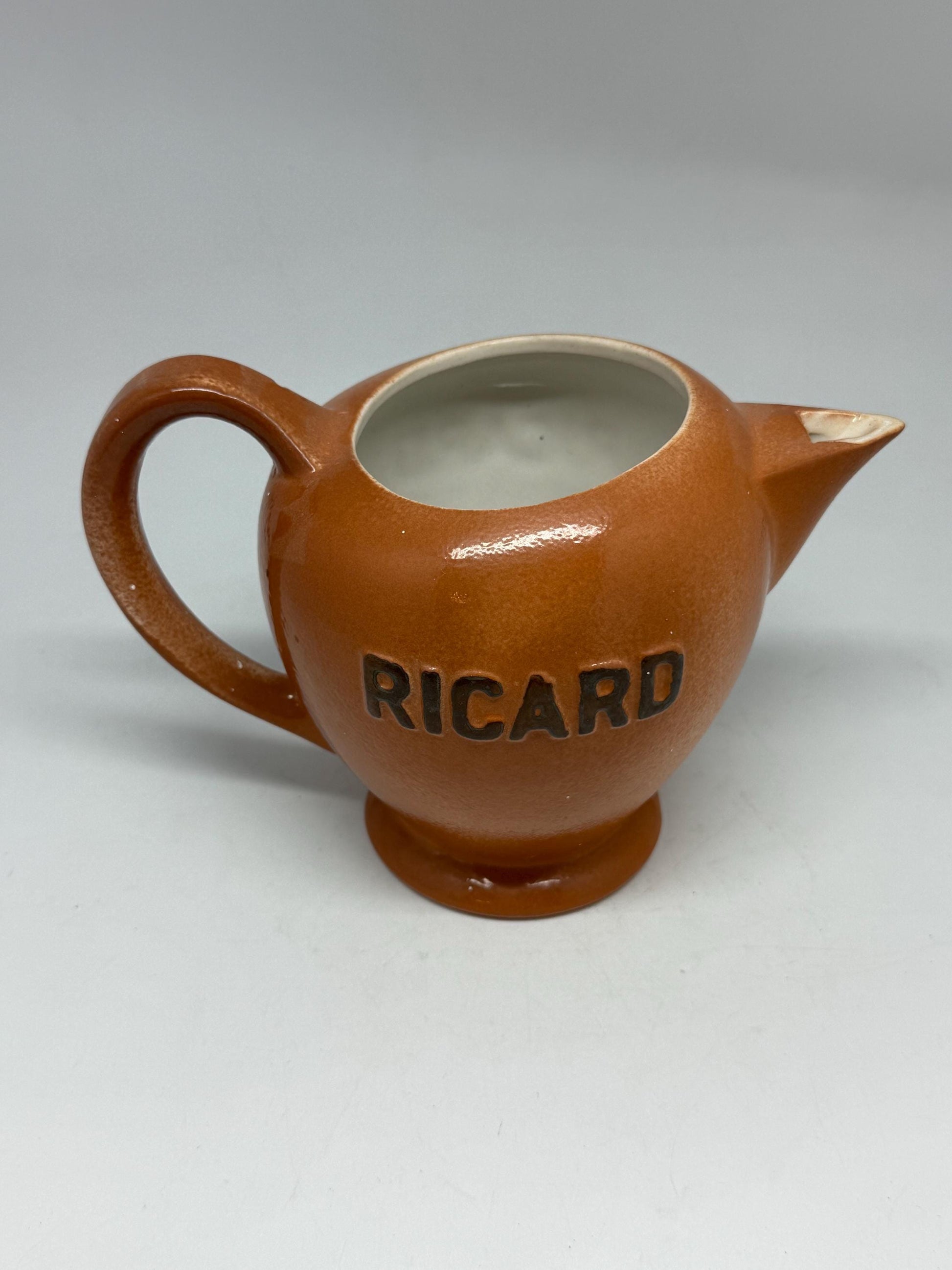 Vintage terracotta Ricard pitcher, ceramic feel, rounded glossy body, iconic branding, retro 80s vibe, tabletop decor