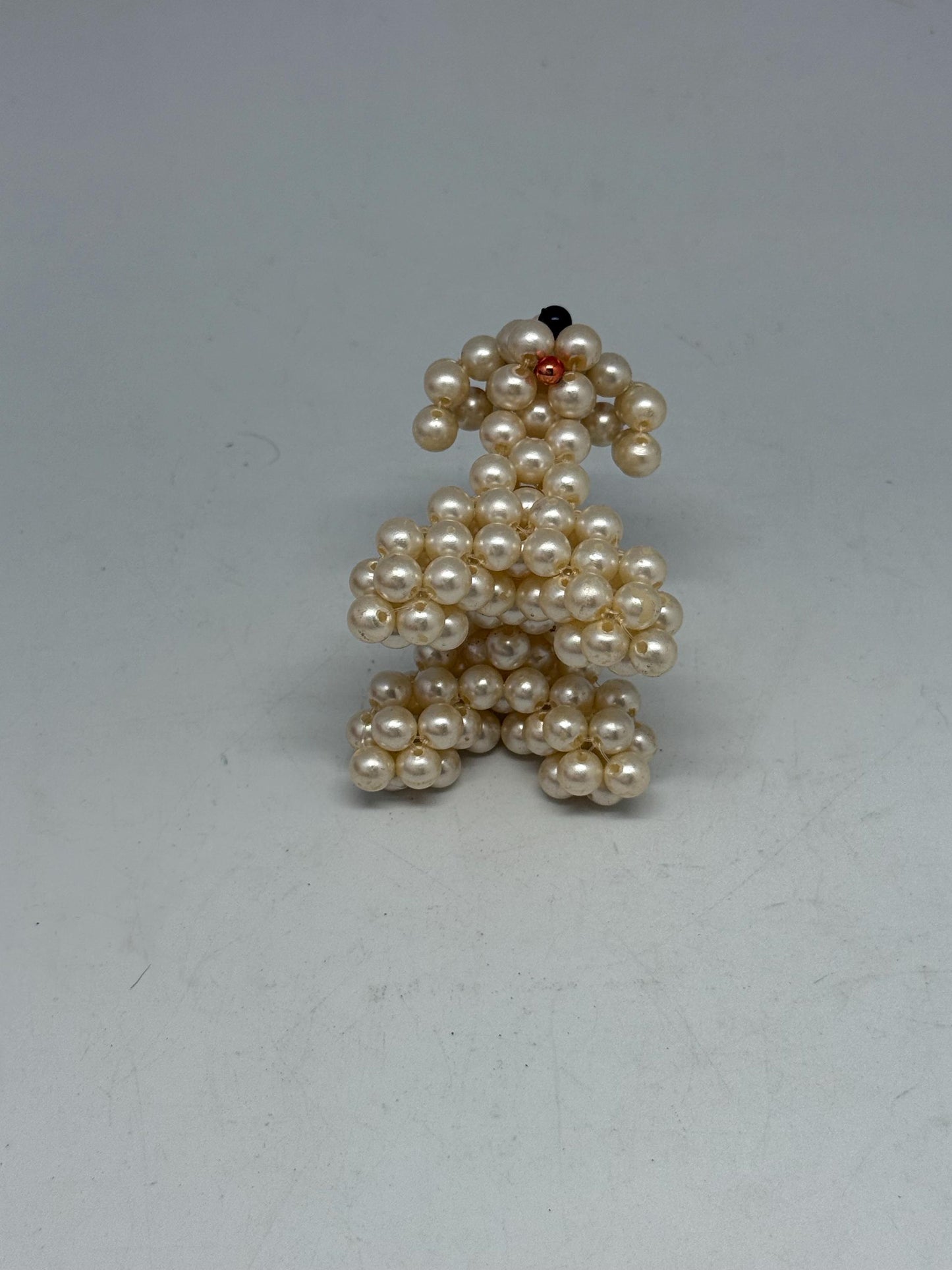 Hand Beaded Pearl Dog Sculpture — fabric close-up