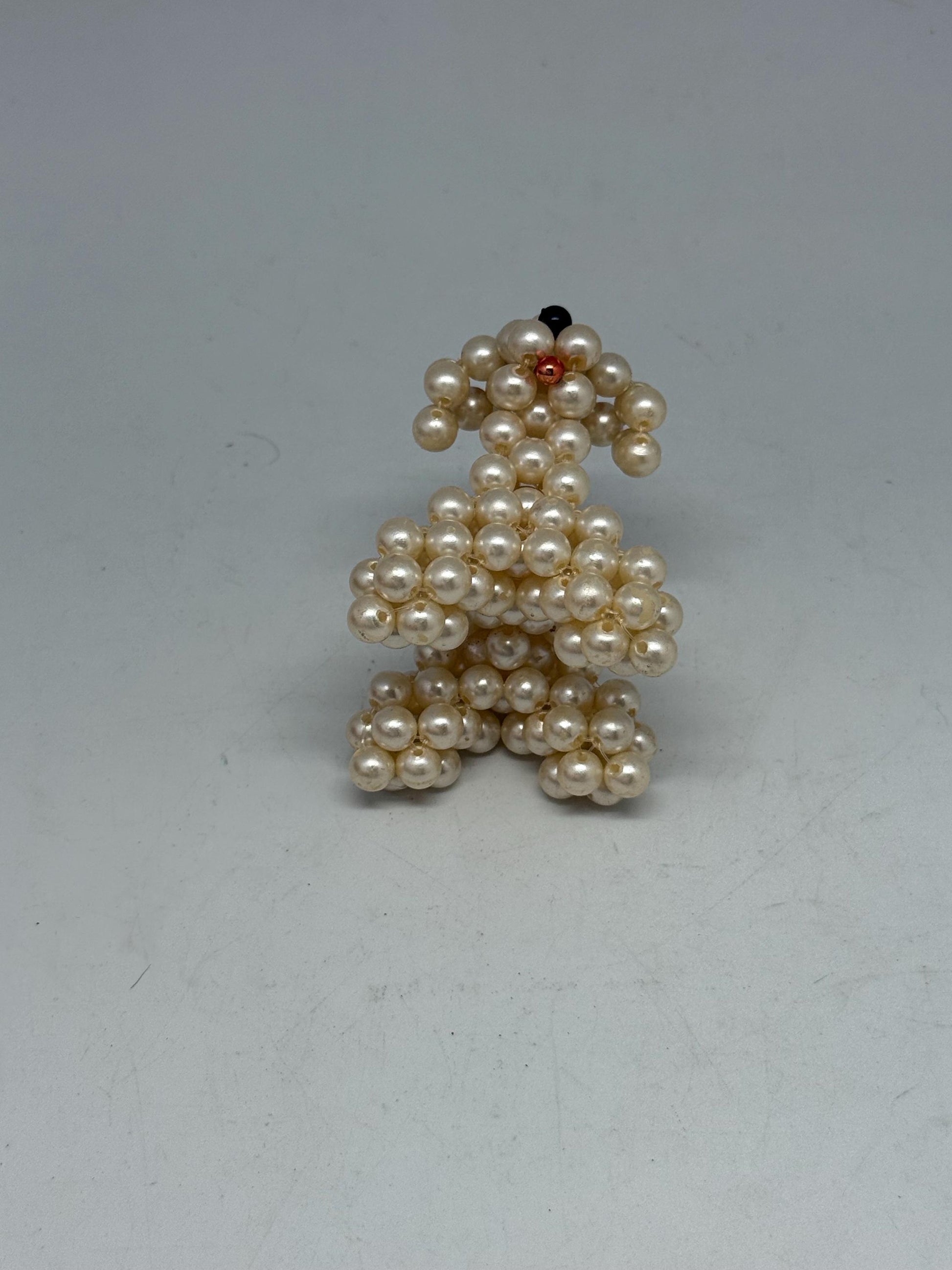 Hand Beaded Pearl Dog Sculpture — fabric close-up