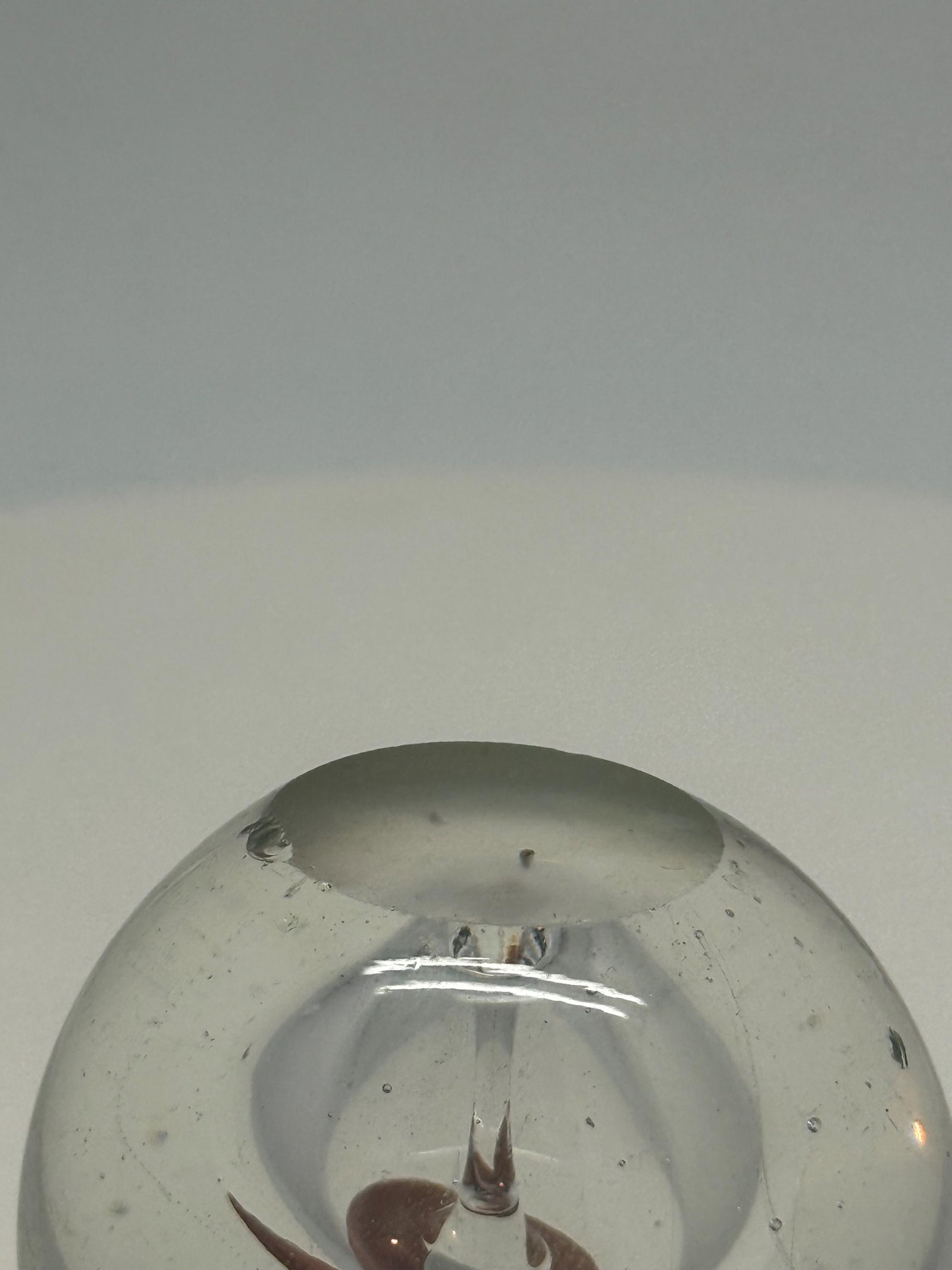 Artistic Clear Glass Sphere with Bubble Inclusions — fabric close-up