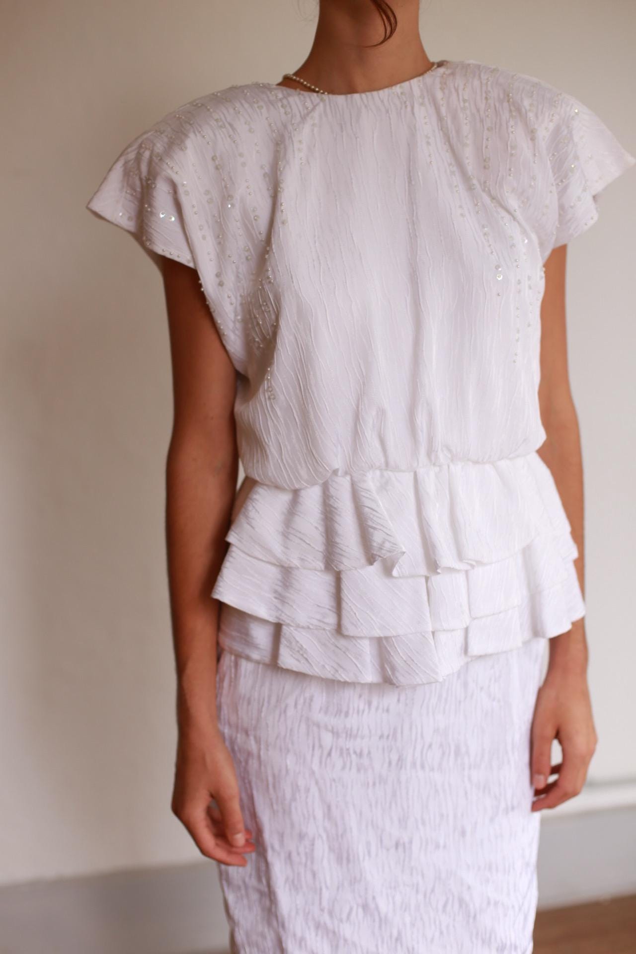 Textured White Knee-Length Peplum Dress — fabric close-up